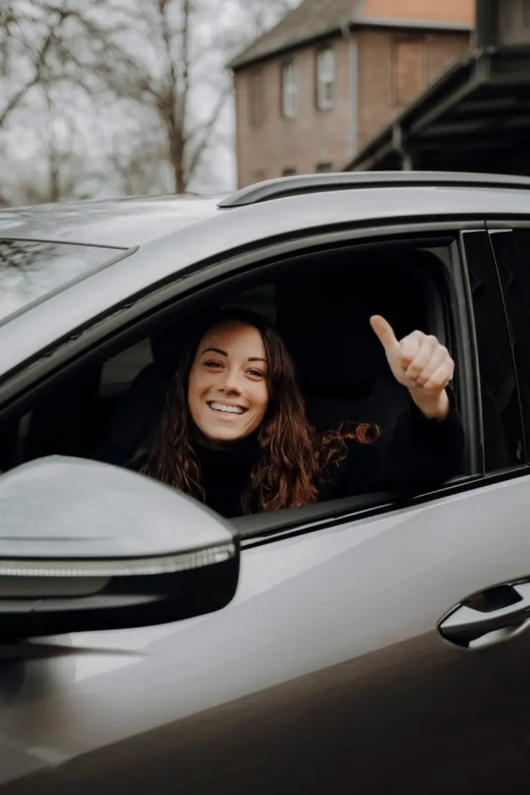Frau am Steuer mit Daumen hoch